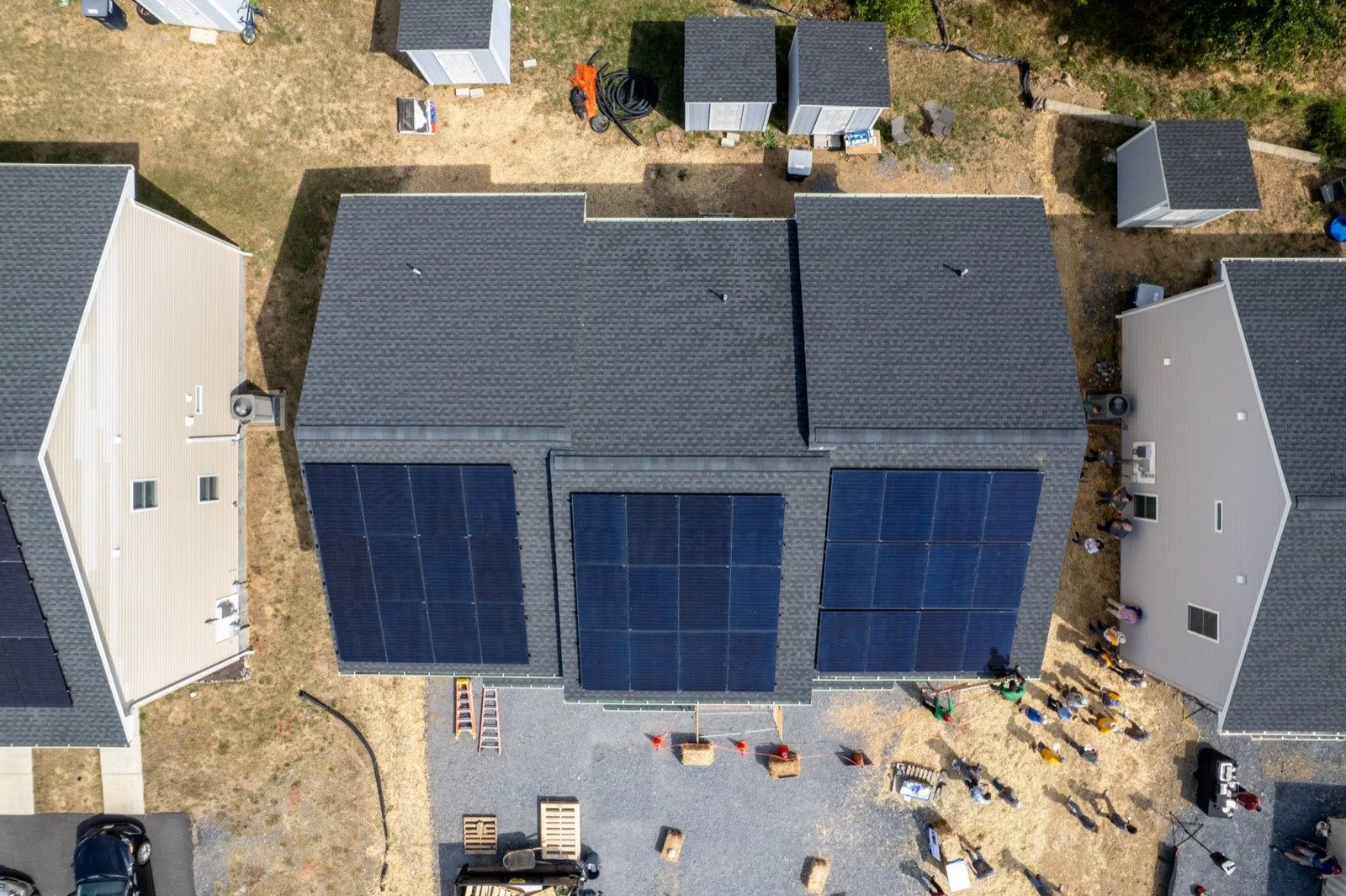 Two finished Habitat homes side by side, each with a rooftop solar array, seen from above.